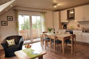 cocina y comedor con mesa y sillas en Urlaub auf dem Bauernhof Marx en Kelberg