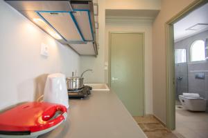 a kitchen with a red appliance on a counter at Mare Dentro Kalamaki Beachroad Apts in Kalamaki