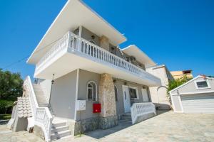 une maison blanche avec des escaliers en face de celle-ci dans l'établissement Mare Dentro Kalamaki Beachroad Apts, à Kalamaki