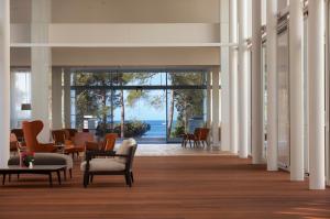 eine Lobby mit Stühlen und Tischen und Meerblick in der Unterkunft Hotel Bellevue in Mali Lošinj