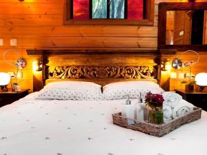 una camera da letto con letto con testiera in legno e candele di First Light Cabins ad Amirim