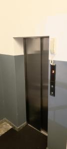 a silver elevator with a phone on a wall at Memory Lane in Colombo