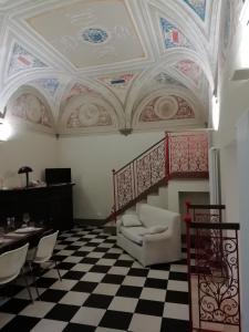 Una sala de estar con una silla blanca y un techo. en Real Taste of Siena, en Siena