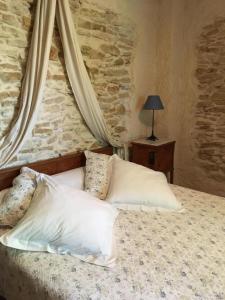 a bed in a room with a stone wall at La Mandarine in Piolenc
