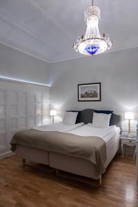 a bedroom with a large white bed and a chandelier at Crystal Plaza Hotel in Stockholm