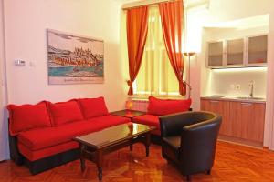 a living room with a red couch and a chair at Central Apartments in Belgrade