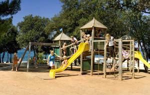 een groep kinderen die spelen op een speelplaats bij Victoria Mobilehome in Orsera Camping Resort in Vrsar