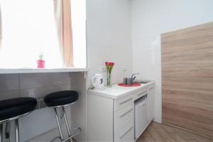 - une petite cuisine avec un évier et deux tabourets dans l'établissement Міні-Smart економ квартира в центрі для пари-3 хв до Оперного Театру, à Lviv
