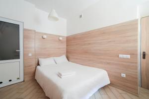- une chambre avec un lit blanc et une télévision à écran plat dans l'établissement Міні-Smart економ квартира в центрі для пари-3 хв до Оперного Театру, à Lviv