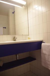 y baño con lavabo y espejo. en Hotel Belambra Le Normont, en Dourdan