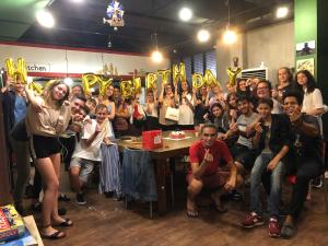 a group of people sitting in a room with their hands up at Doobaki Hostel in Gyeongju