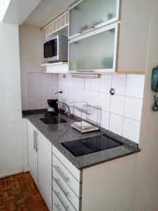 eine kleine Küche mit einer Spüle und einer Mikrowelle in der Unterkunft Studio en Microcentro in Buenos Aires