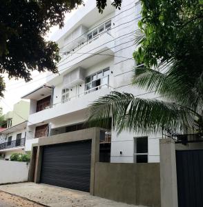a white building with a parking garage in front of it at Memory Lane in Colombo