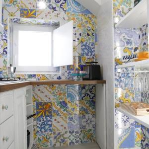 cocina con azulejos azules y blancos en la pared en La Casetta di Meta, en Meta