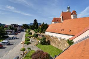 a building with a red roof next to a street at Apartmán u Brány in Prachatice