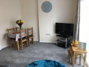 a living room with a table and a clock on the wall at Wristland Court, Watchet in Watchet