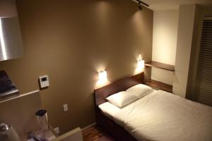 a bedroom with a bed and two lights on the wall at Condominium MIRAHAKONE in Hakone