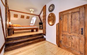 a room with a wooden door and a bed at Apartmán u Brány in Prachatice