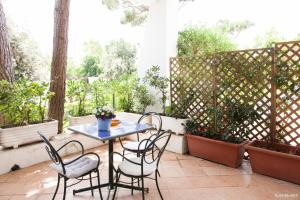 a patio with a table and chairs and potted plants at Il Miraggio in Fregene