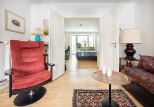 ein Wohnzimmer mit einem roten Stuhl und einem Sofa in der Unterkunft Central beautiful 1 bedroom apartment with terrace in Kopenhagen