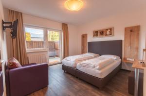 1 dormitorio con 2 camas, sofá y ventana en Pension Max, en Zell am See