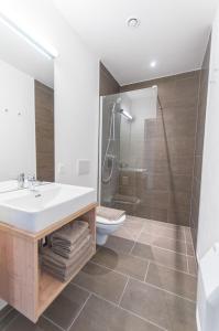 La salle de bains est pourvue d'un lavabo, de toilettes et d'une douche. dans l'établissement Pension Max, à Zell am See