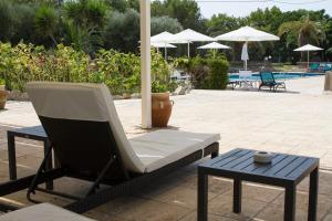 eine Terrasse mit einem Stuhl, einem Tisch und einem Sonnenschirm in der Unterkunft Residence Conchiglia San Giovanni in Santa Cesarea Terme