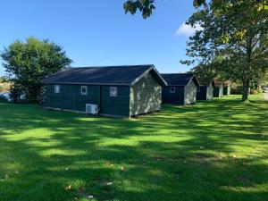 a row of houses in a field of grass at Tangloppen Camping & Cottages in Ishøj