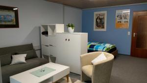 貝西格海姆的住宿－Inas Ferienwohnungen，客厅配有沙发、桌子和床。