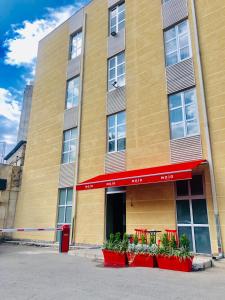 a building with red plants in front of it at Boutique Hotel MOJO in Tbilisi City