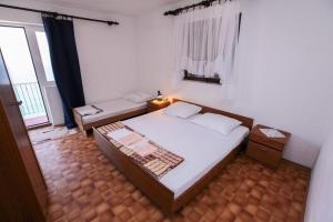 a small bedroom with a bed and a window at Robinson Tabinja in Sućuraj