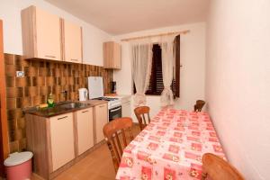 a kitchen with a table and chairs and a kitchen with a table and a counter at Robinson Tabinja in Sućuraj