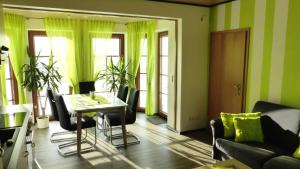 uma sala de estar com paredes verdes e uma mesa e cadeiras em Ferienwohnung Dunja em Winterberg