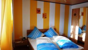una camera da letto con letto a righe blu e bianche di Ferienwohnung Dunja a Winterberg