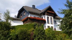 duży biały dom z czarnym dachem w obiekcie Ferienwohnung Dunja w mieście Winterberg