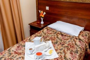 um quarto de hotel com uma bandeja de comida numa cama em Галицька Корона em Lviv
