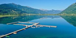 a dock on a lake with mountains in the background at Apartmani Ambiente in Plav