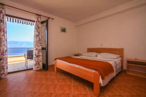 a bedroom with a bed with a view of the ocean at Robinson Merlot in Bogomolje