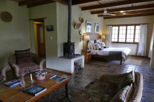 a living room with a bed and a fireplace at The Retreat at Groenfontein in Calitzdorp