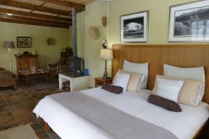 1 dormitorio con 1 cama grande con almohadas blancas en The Retreat at Groenfontein, en Calitzdorp