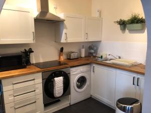 uma cozinha com uma máquina de lavar roupa e um lavatório em Number 10 service apartment - Danes em Southampton