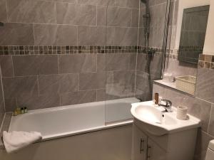 bagno con lavandino, vasca e lavandino di Number 10 service apartment - Danes a Southampton