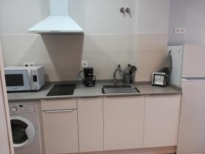 a small kitchen with a microwave and a refrigerator at Apartamento tranquilo y luminoso in Mundaka