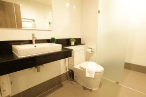 a bathroom with a white toilet and a sink at Lampang Residence in Lampang