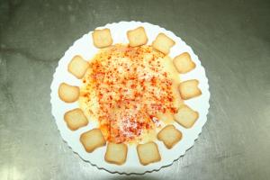 einen Teller mit einer Käsepizza auf dem Tisch in der Unterkunft Bungalows Camping Parque Nacional de Monfragüe in Malpartida de Plasencia