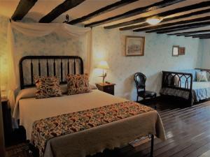 sypialnia z dużym łóżkiem i krzesłem w obiekcie Los Colmenares w mieście Cuzcurrita-Río Tirón