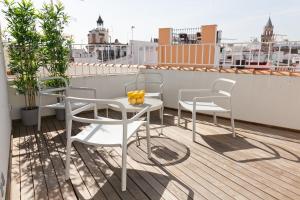 d'un balcon sur le toit avec une table et des chaises. dans l'établissement GoToSeville GERONA SUITES, à Séville