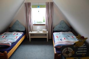 two twin beds in a room with a window at Ostsee-Ferienwohnung-Nautikuss in Wangels