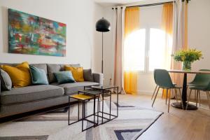 una sala de estar con un sofá y una mesa en GoToSeville GERONA SUITES, en Sevilla