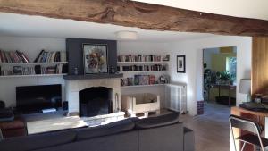 a living room with a couch and a fireplace at Ancien presbytère in Le Torpt